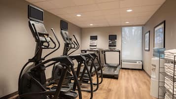 A fitness center with treadmills, a water cooler, and a towel rack.