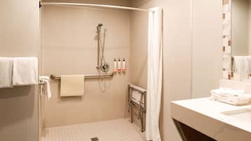 A bathroom with a shower, a towel rack, and a sink.