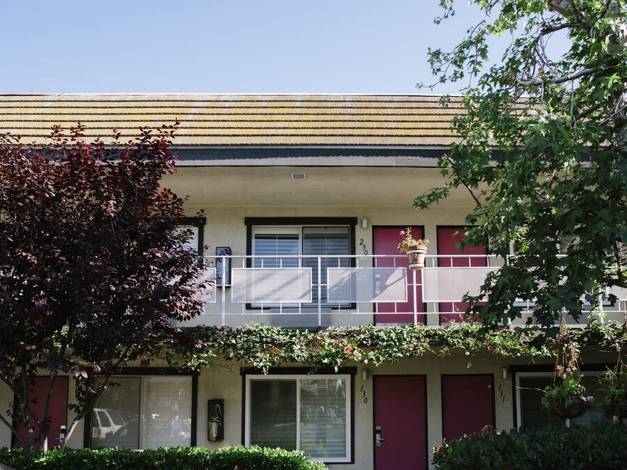 Un immeuble de deux étages doté d’un balcon, de grandes fenêtres et d’une porte portant un numéro.
