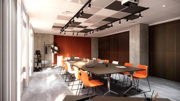 A conference room with a long table, orange chairs, and a projector.
