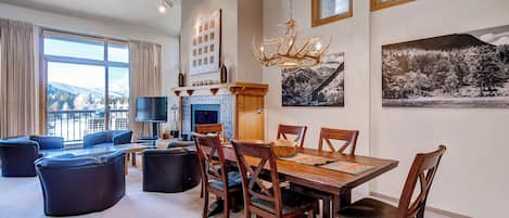 A spacious living area with a fireplace, dining table, and comfortable seating.