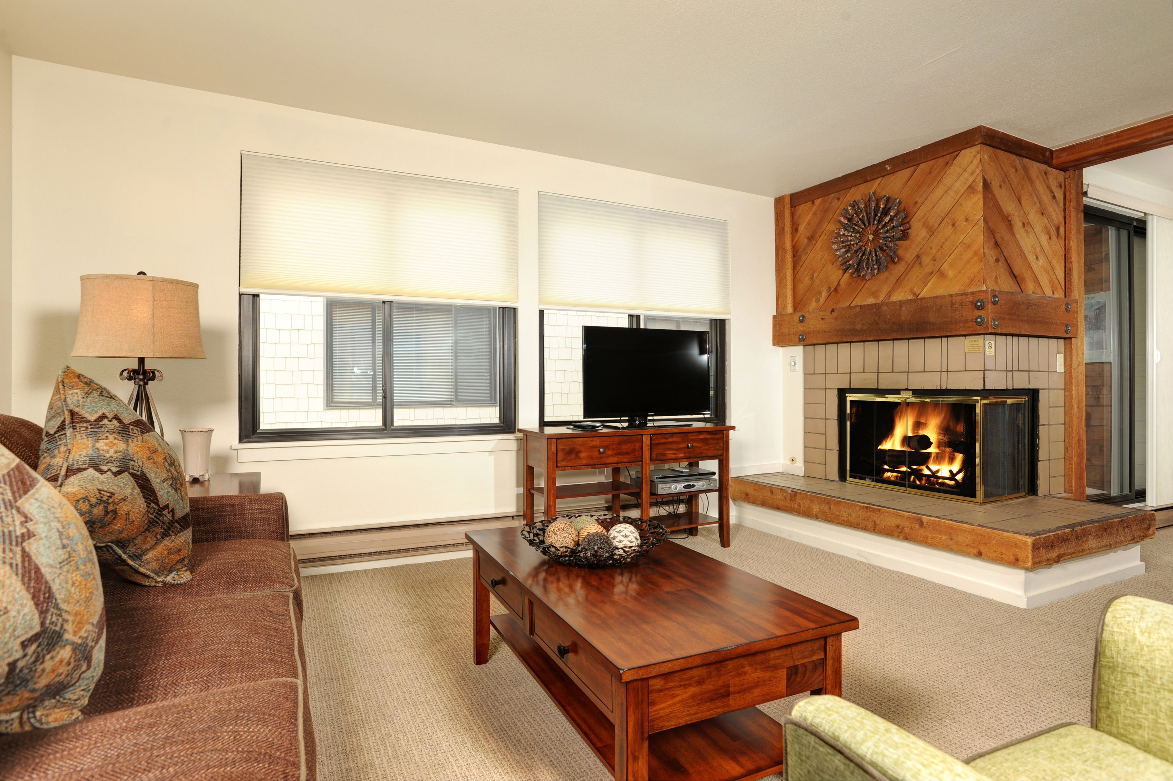 A living room with a fireplace, a television, and a sofa.