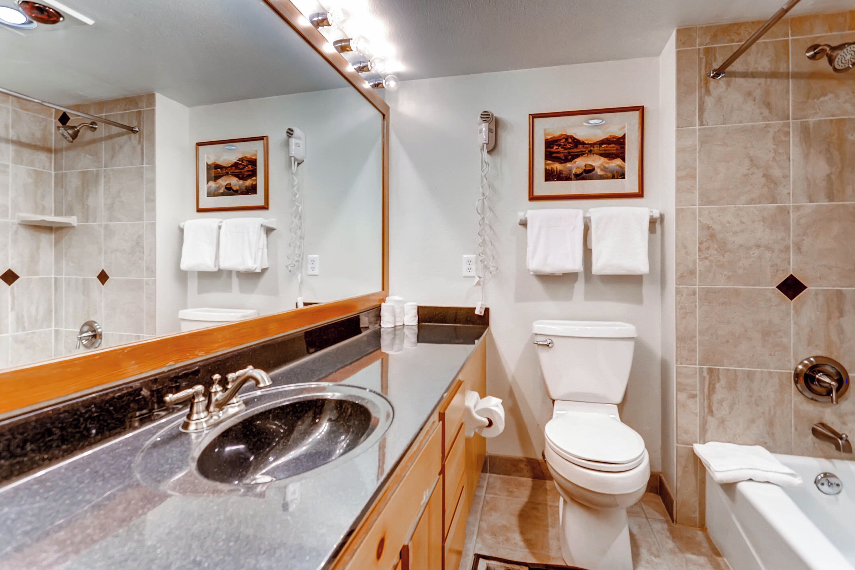 A modern bathroom with a sink, toilet, and bathtub.