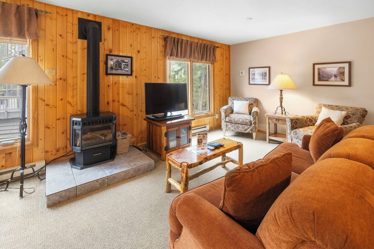 A cozy living room with a fireplace, a television, and comfortable seating.