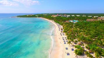 Privat strand, vit sandstrand, solstolar och parasoller
