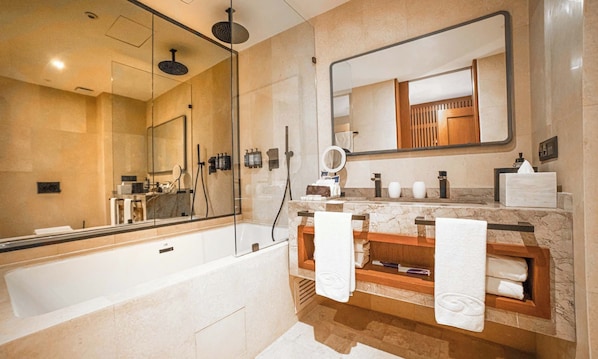 Un baño moderno con un espejo grande, una bañera y un tocador con un estante de madera.