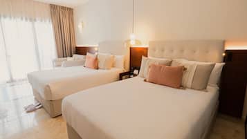 A hotel room with two beds, a large window with curtains, and a nightstand with a lamp.