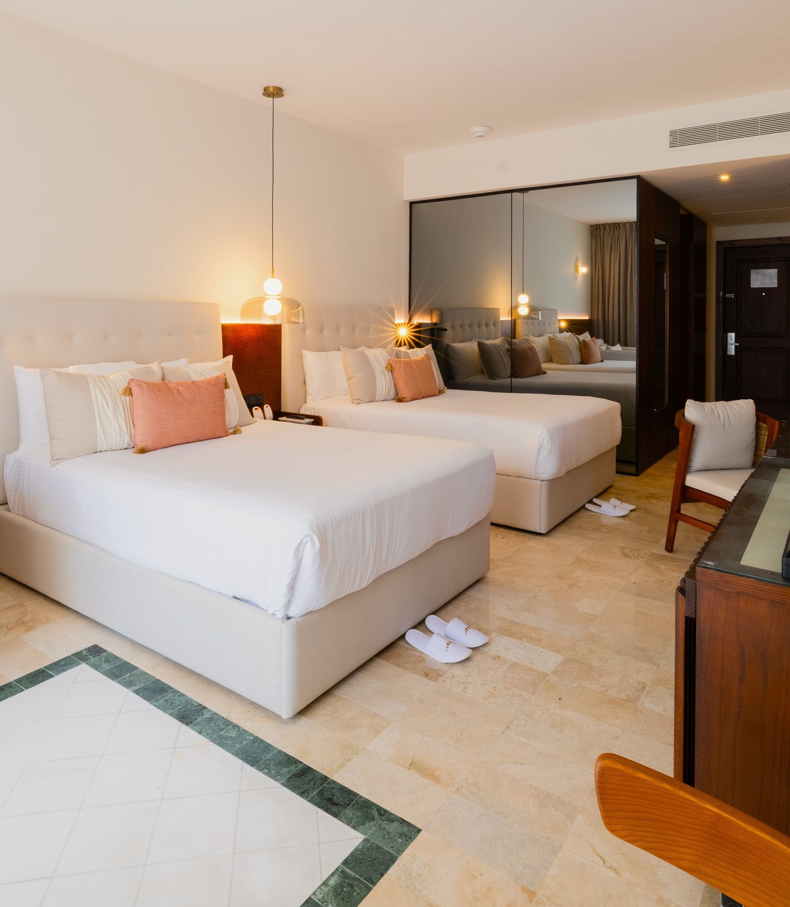 Una habitación de hotel con dos camas, un escritorio y una silla.