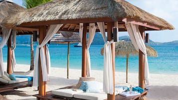 Aan het strand, wit zand, ligstoelen aan het strand, parasols