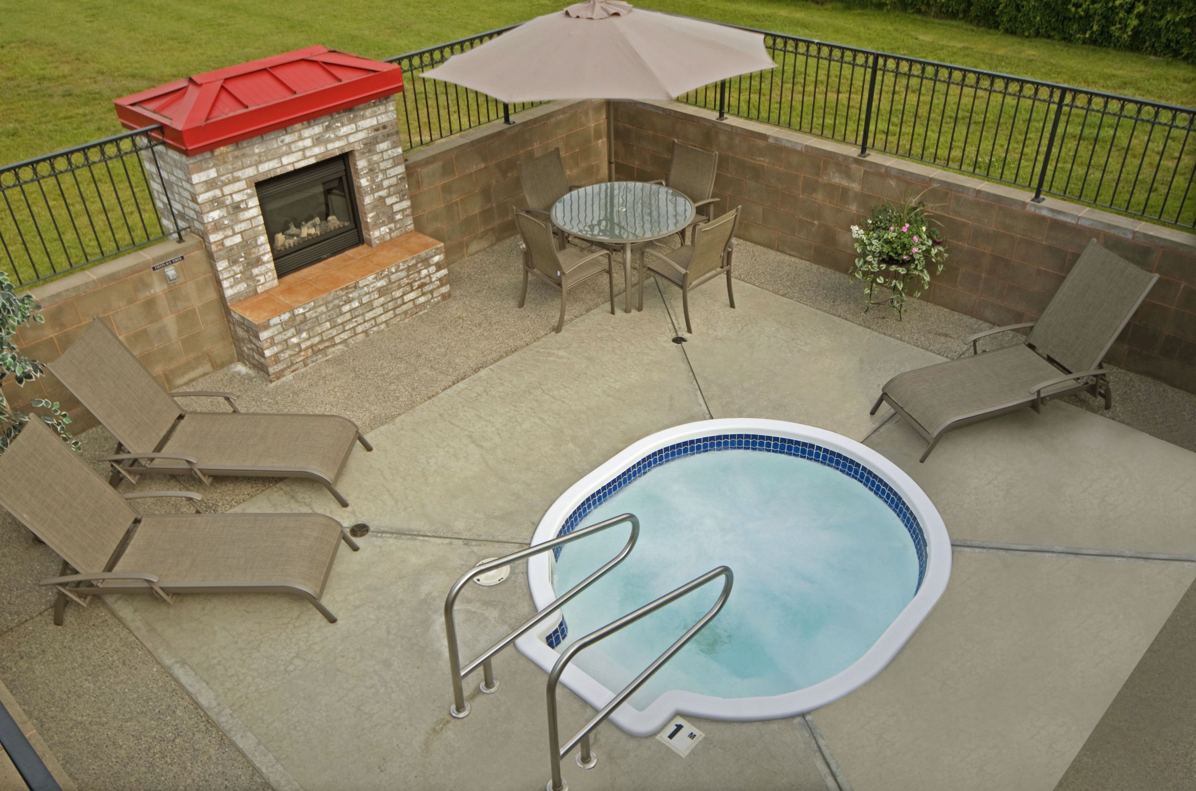 A backyard with a swimming pool, a fire pit, and outdoor furniture.