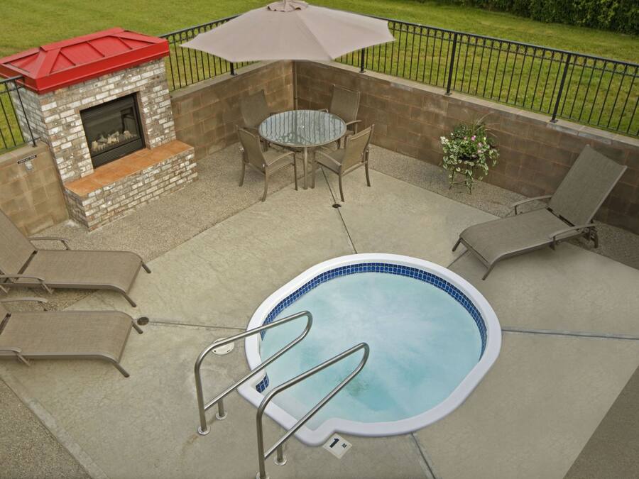 A backyard with a swimming pool, a fire pit, and outdoor furniture.