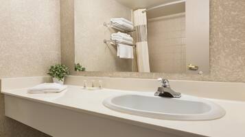 A bathroom with a sink, mirror, and towel rack.