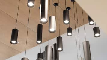 Un interior moderno con lámparas colgantes cilíndricas y techo de madera.