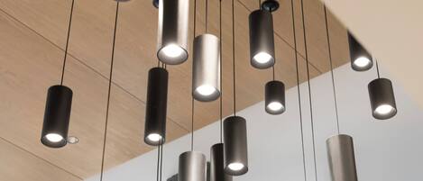 Un intérieur moderne avec des suspensions cylindriques et un plafond en bois.