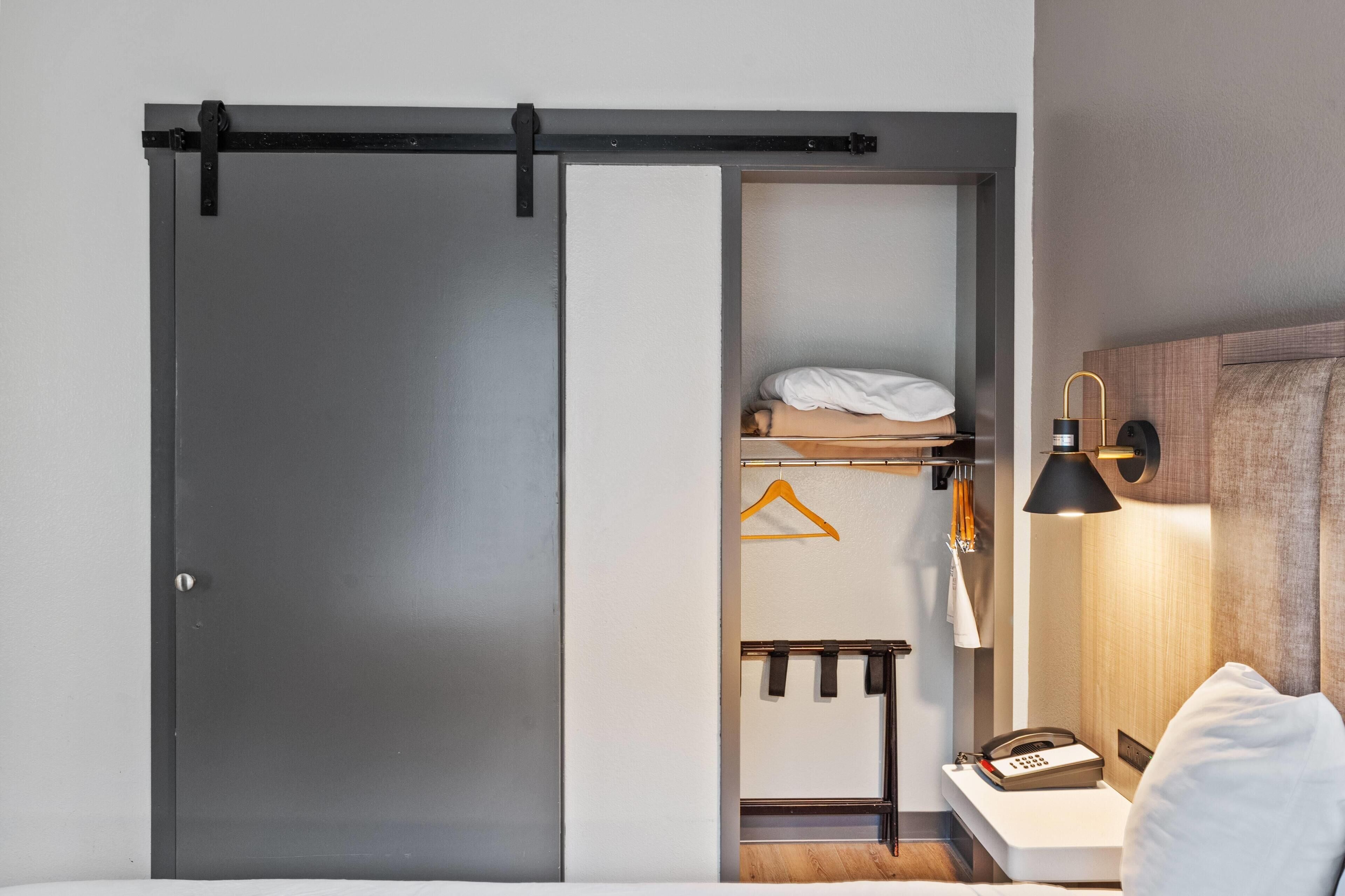 Un dormitorio con cama, mesita de noche, lámpara y un armario con puerta corredera.