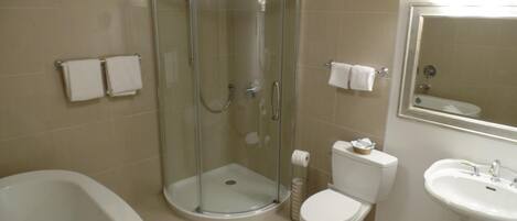 A bathroom with a glass-enclosed shower, a toilet, a sink, and a bathtub.