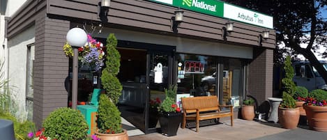 A National Arbutus Inn with a clear entrance, outdoor seating, and potted plants.