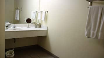 Une salle de bain équipée d’un lavabo, d’un miroir et d’un porte-serviettes.