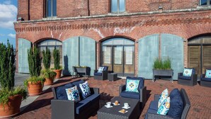 An outdoor seating area with wicker furniture and potted plants. - The Inn at Henderson's Wharf, an Ascend Collection Hotel (Baltimore)