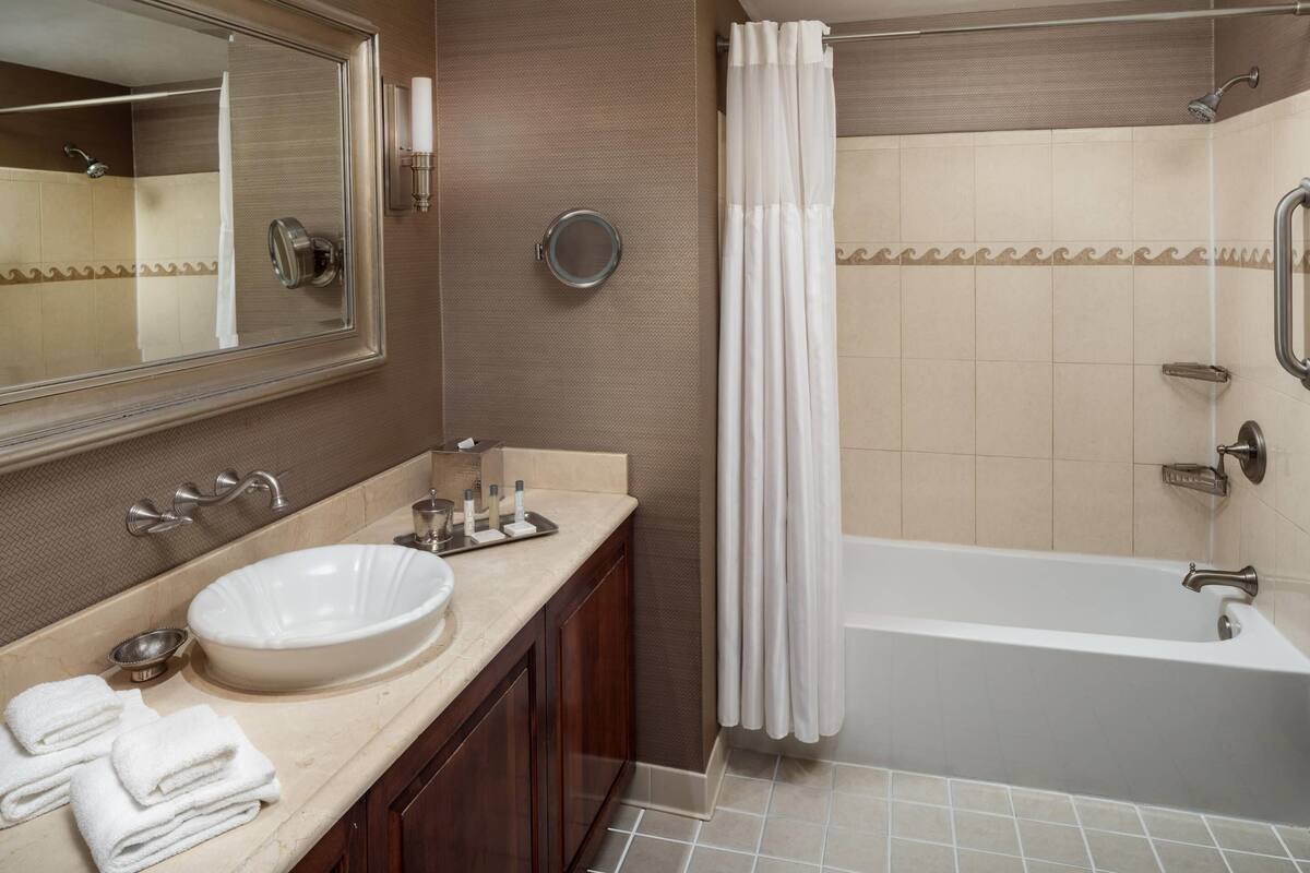combined shower/bathtub, designer toiletries, hair dryer, towels