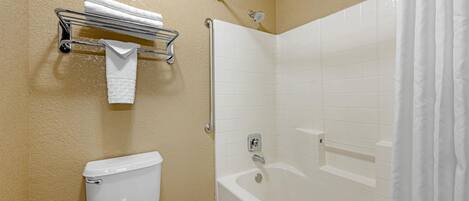 A bathroom with a toilet, a shower with a glass door, and a towel rack with a towel.