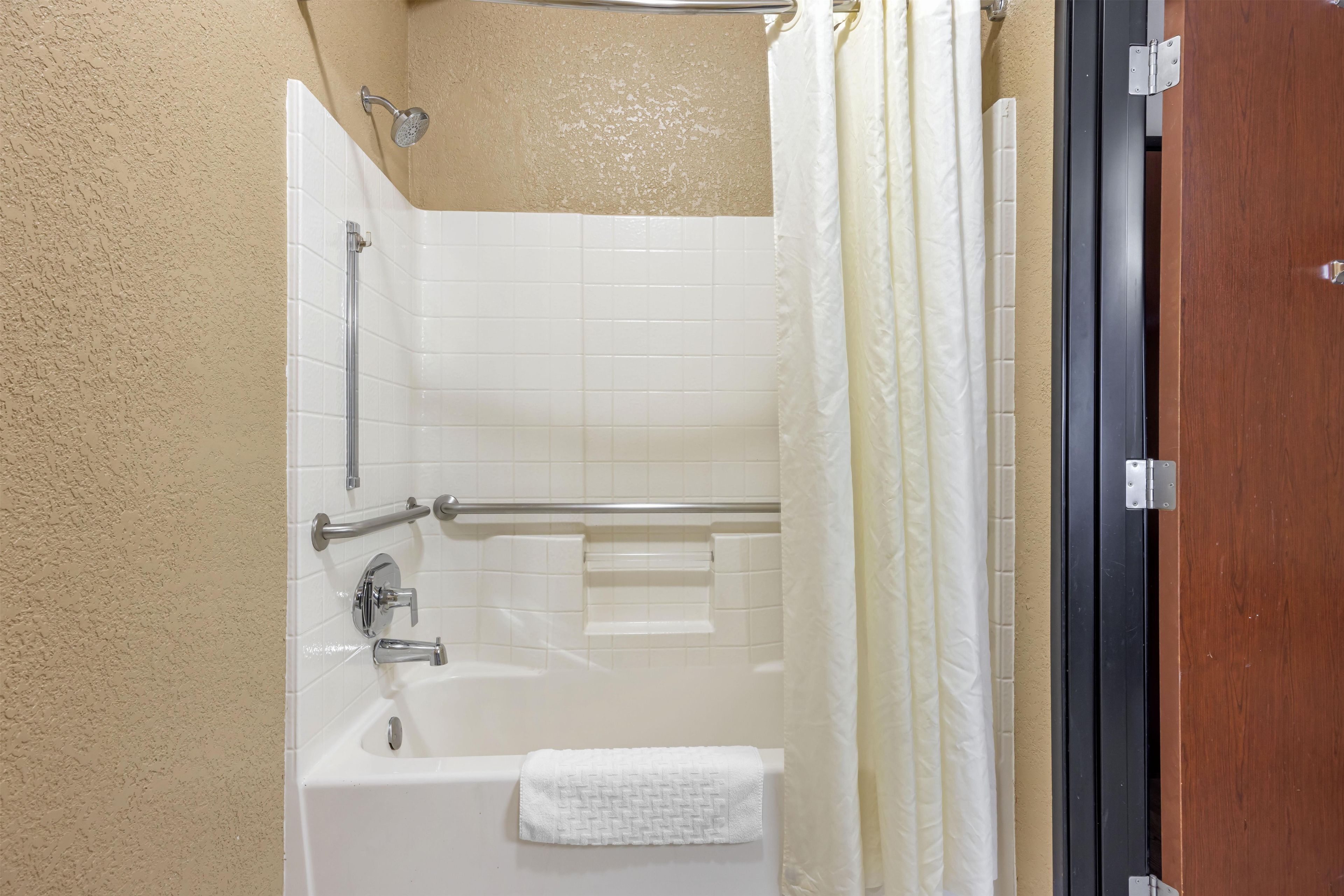 A bathroom with a bathtub, a shower, and a towel rack.