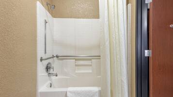 A bathroom with a bathtub, a shower, and a towel rack.