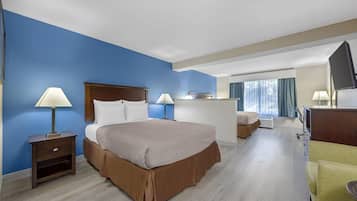 A hotel room with a large bed, bedside tables, a desk, and a chair.