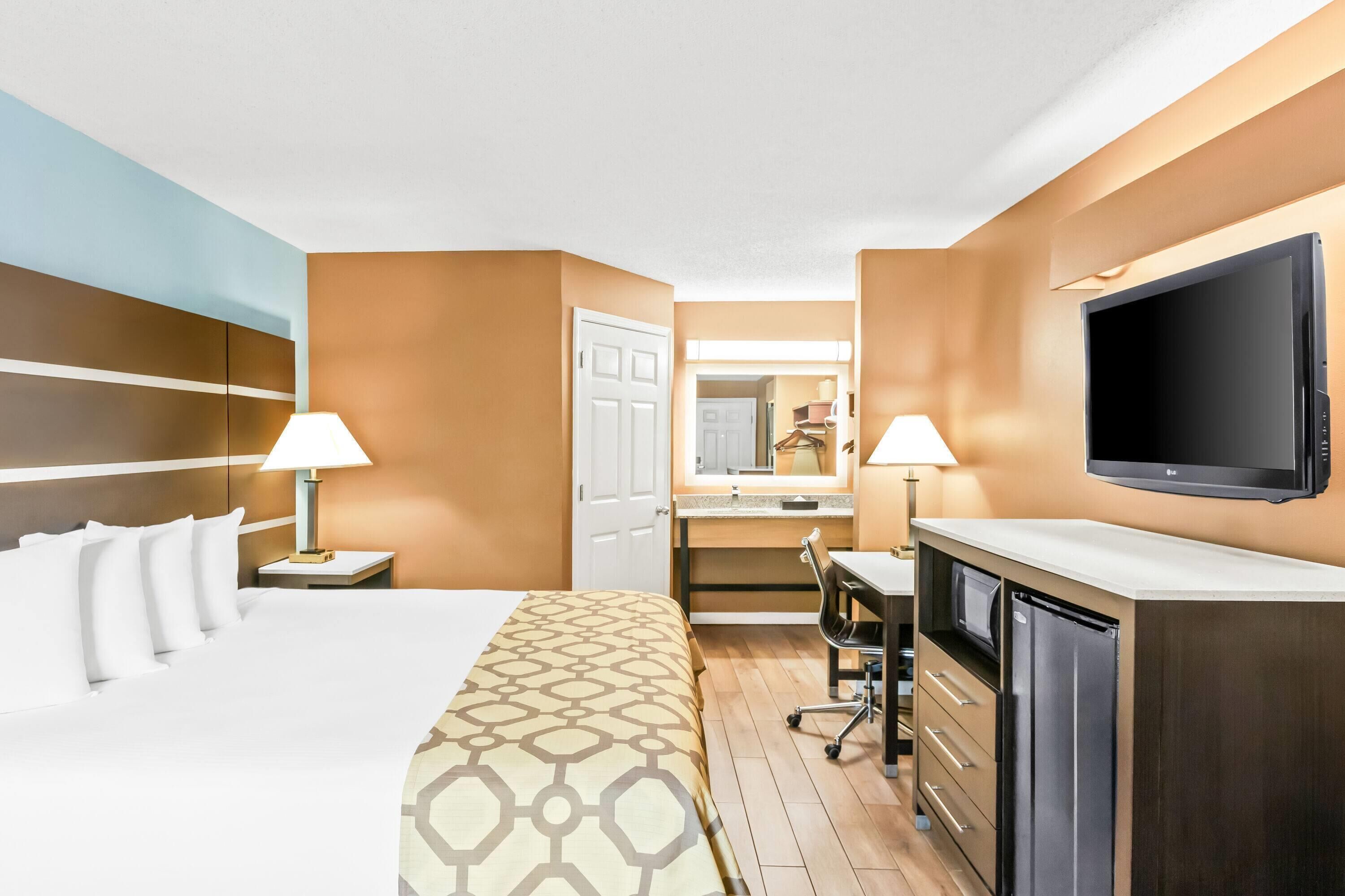 Une chambre d’hôtel équipée d’un lit, d’un bureau, d’une chaise et d’un téléviseur.