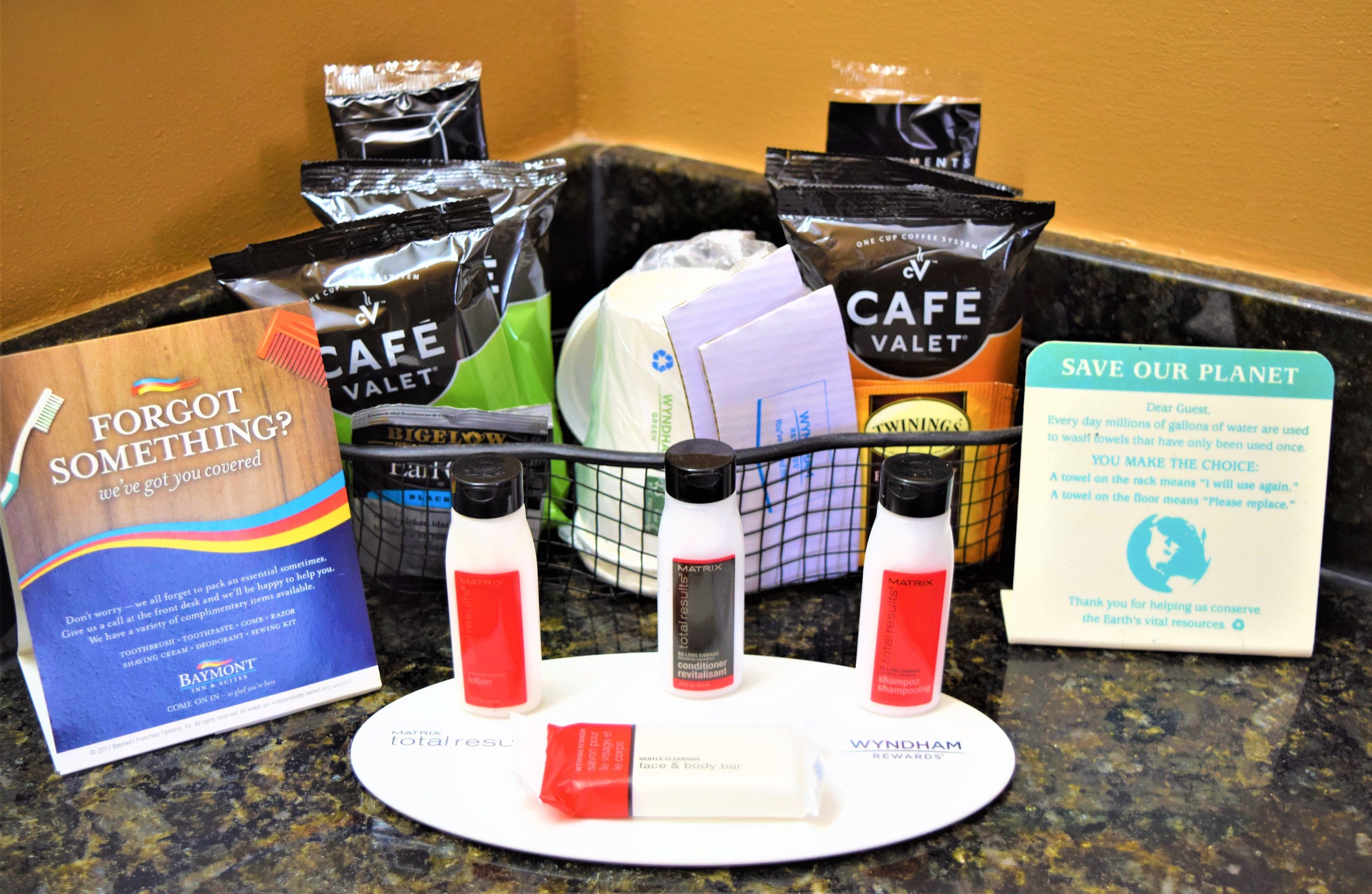 A variety of toiletries and a promotional card on a countertop.