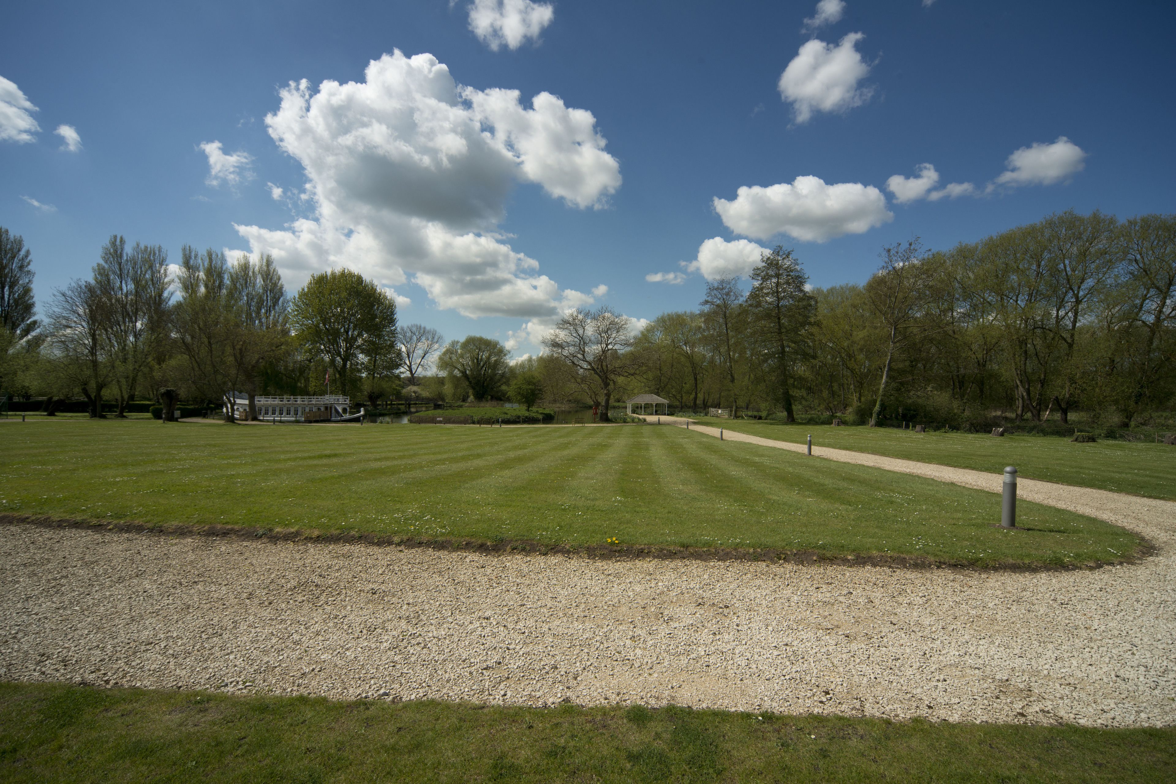 A park with a gravel path, grassy areas, and trees.