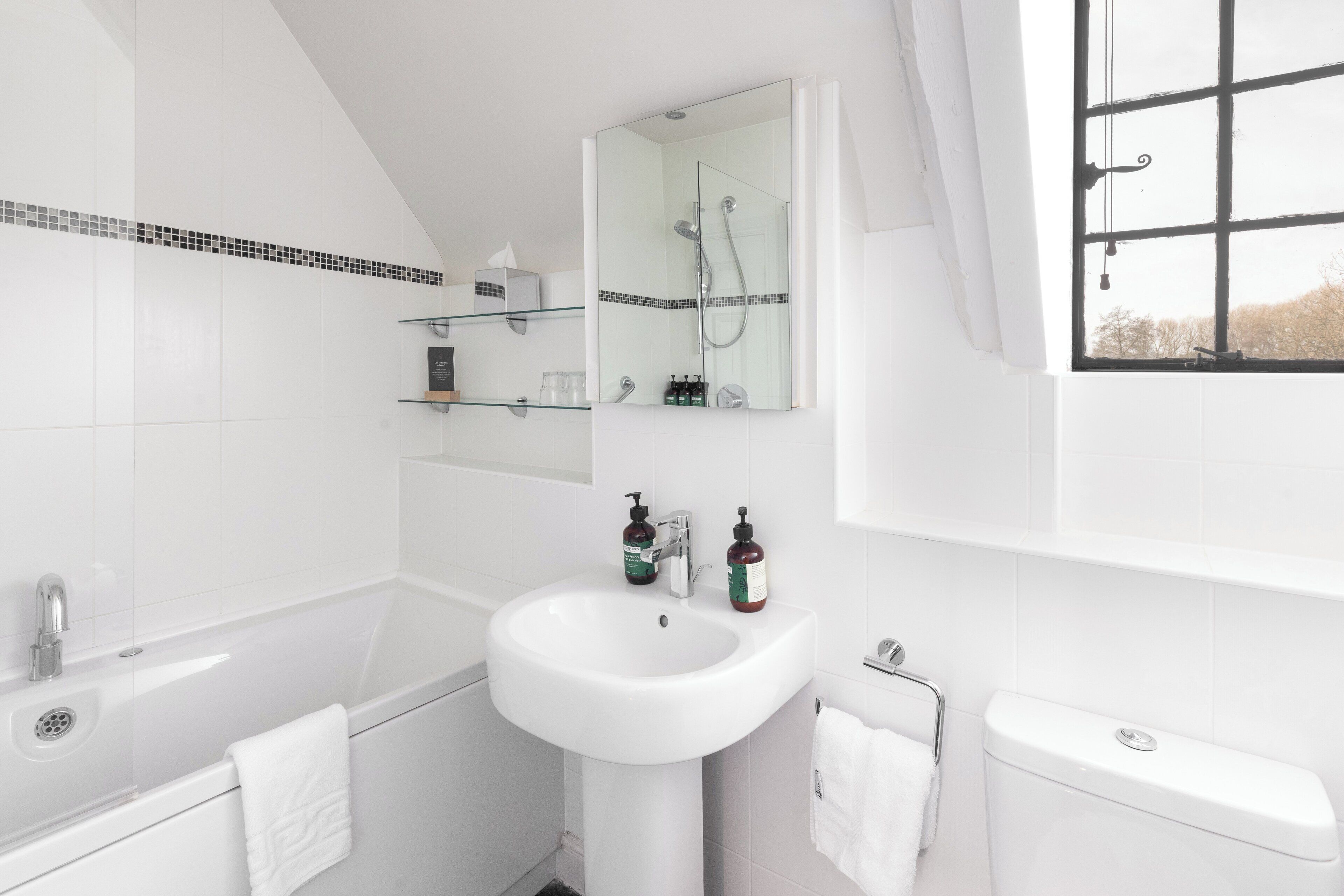 Un bagno moderno con vasca, lavandino, WC e cabina doccia in vetro.