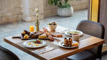 Une table à manger avec des aliments pour le petit-déjeuner, notamment des œufs, des toasts et une salade.
