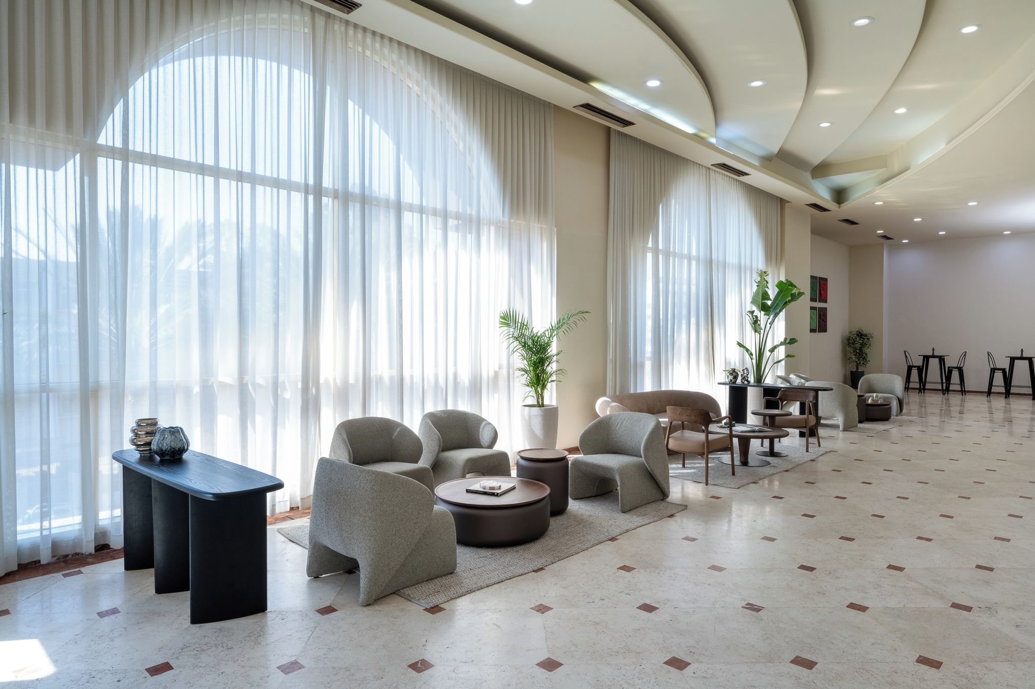 Un vaste espace de détente doté de grandes fenêtres, de sièges confortables et d’un design moderne.