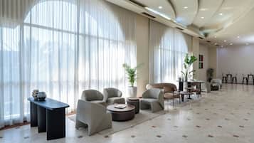 Un vaste espace de détente doté de grandes fenêtres, de sièges confortables et d’un design moderne.