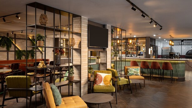 Zona de bar moderna con asientos y barra.