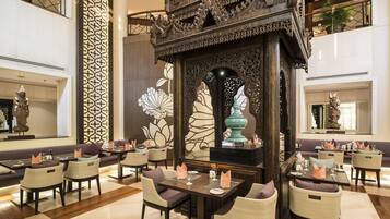A spacious lobby with a traditional wooden altar, seating areas, and decorative wall art.