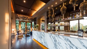 A bar area with a marble countertop, wooden flooring, and hanging light fixtures. - Chatrium Hotel Royal Lake Yangon (Yangon)