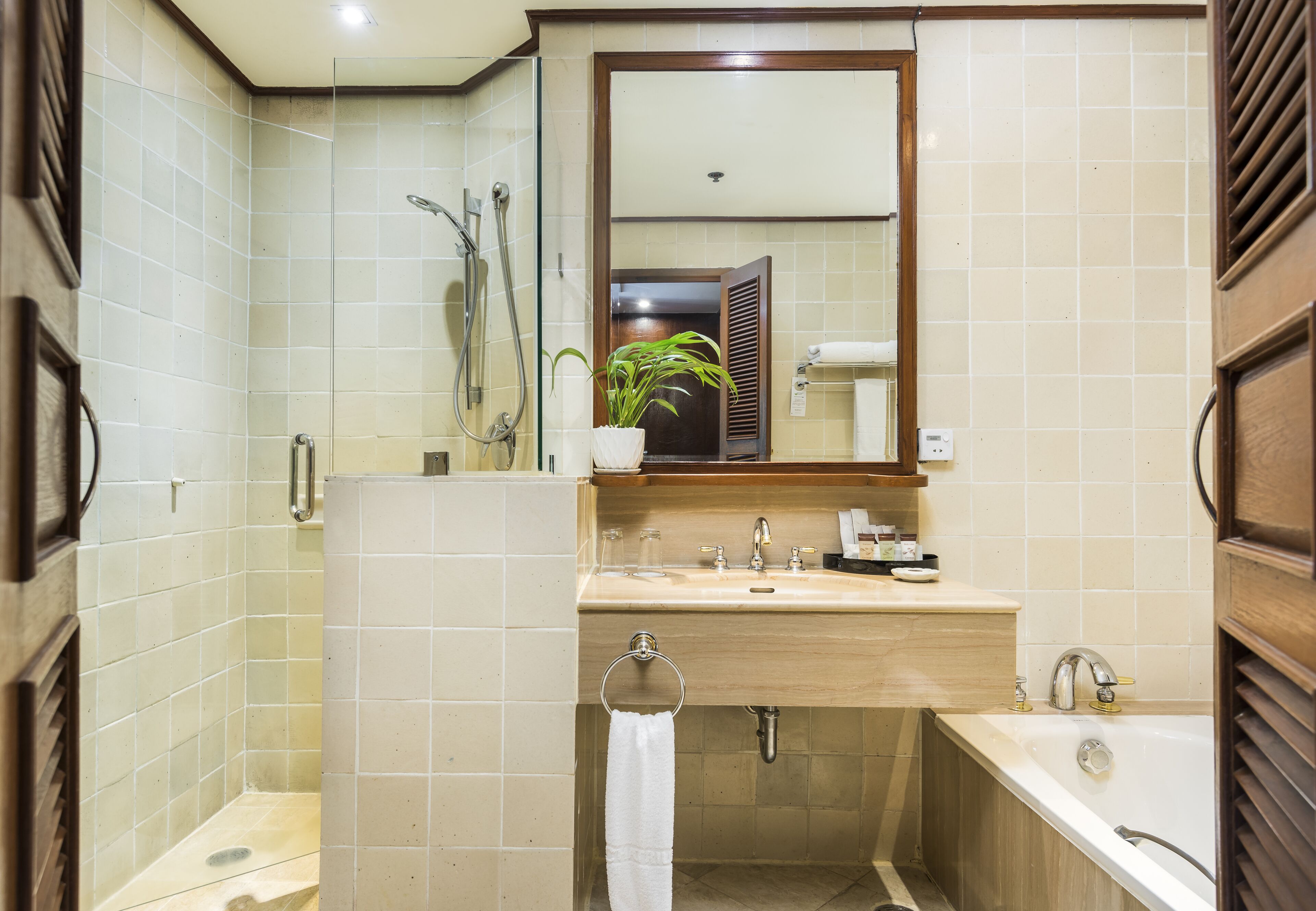 A bathroom with a sink, mirror, and bathtub.