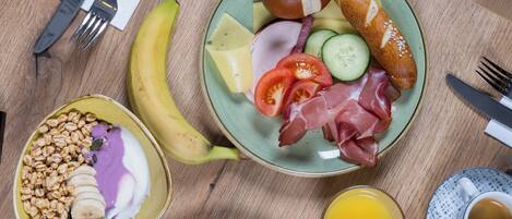 Desayuno con platos de comida, utensilios y una taza de café.