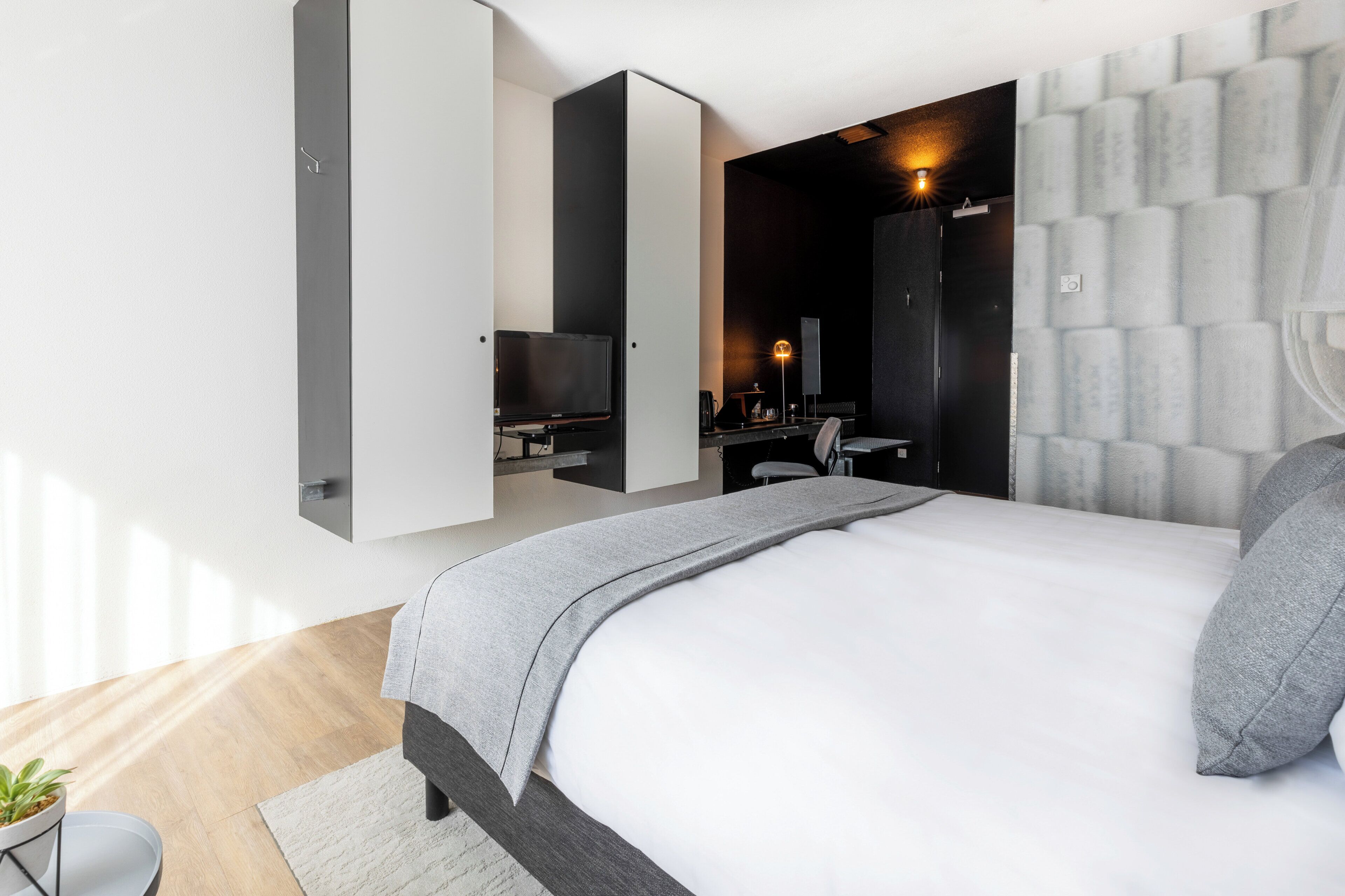 Un dormitorio moderno con una cama, un escritorio y una silla.