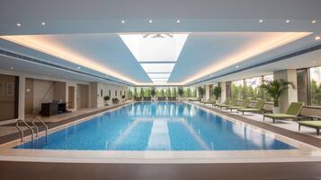 Relax by the pool surrounded by lounge chairs and lush greenery.