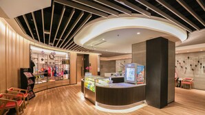 A modern reception area with a curved counter, wooden flooring, and a display of clothing items. - Shangri-La Dalian (Dalian)