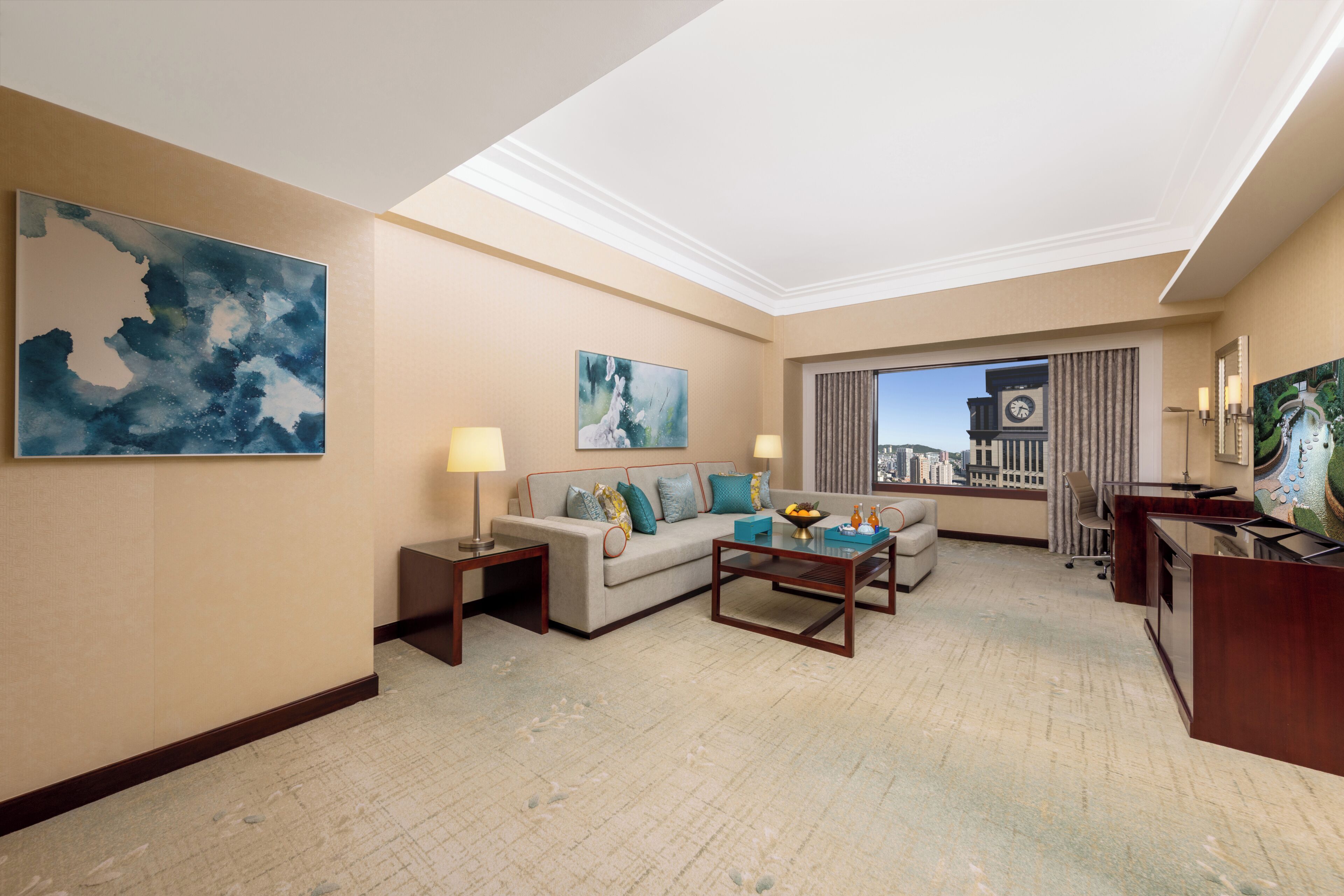 Ein Hotelzimmer mit einer Couch, einem Couchtisch und Kunstwerken an den Wänden.