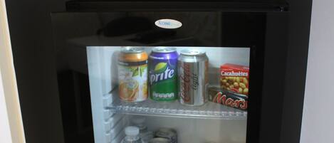 Un refrigerador pequeño con bebidas y un microondas encima.