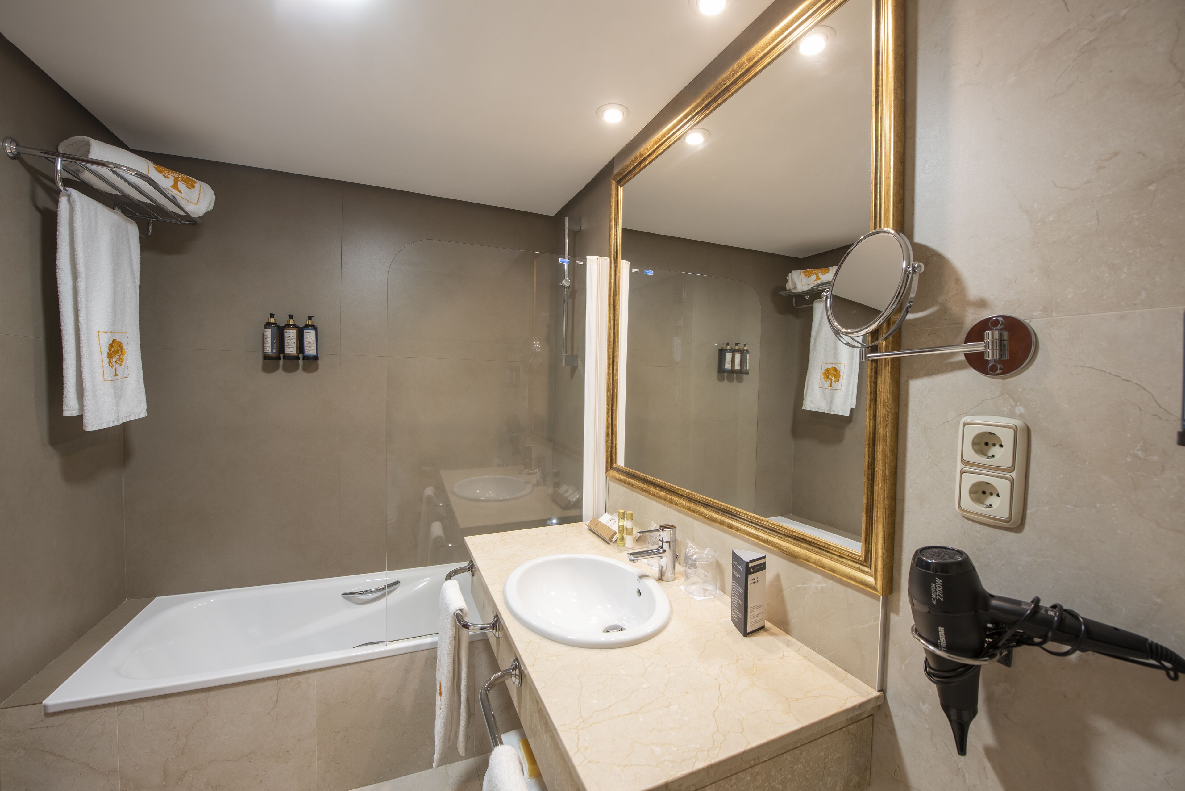 Une salle de bain moderne avec une baignoire, un lavabo et un grand miroir.