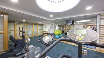 A gym with exercise equipment, a treadmill, and exercise balls.