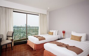 A hotel room with two beds, a chair, a desk, and a large window with a city view. - Somerset Park Suanplu Bangkok (Bangkok)