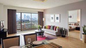Een moderne hotelkamer met een balkon, een zithoek, een woongedeelte en een slaapkamer.