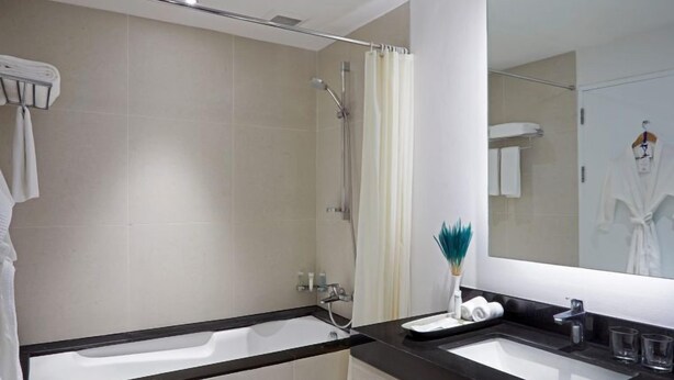 Ein modernes Badezimmer mit zwei Waschbecken, einer Dusche und einem großen Spiegel.